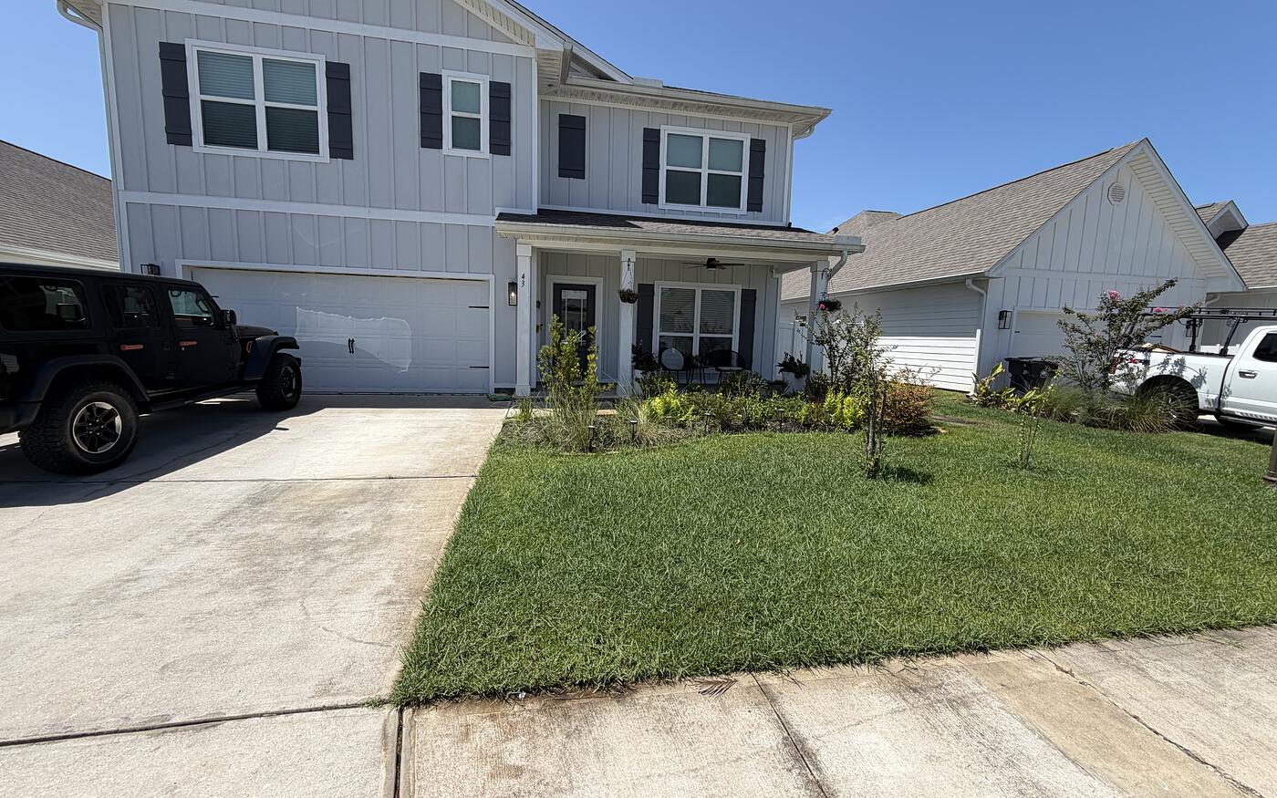 A two story home with a crisp driveway edge and mowed lawn